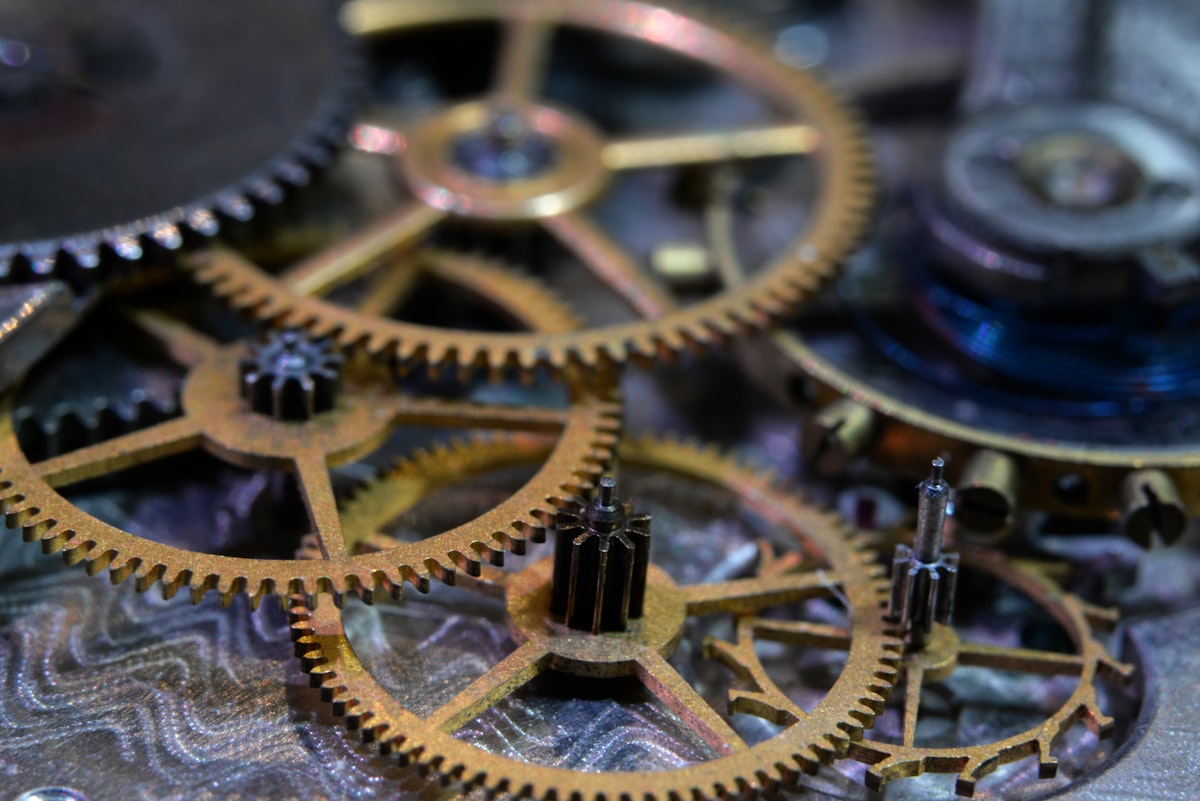 A macro close-up of the gears and cogs of a mechanical watch movement, no identifiable person and no readable brand name or logo, echoing the piece's image of the mechanical caseback of an everyday Swiss watch, for the story on the collapsing middle of the Swiss watch market