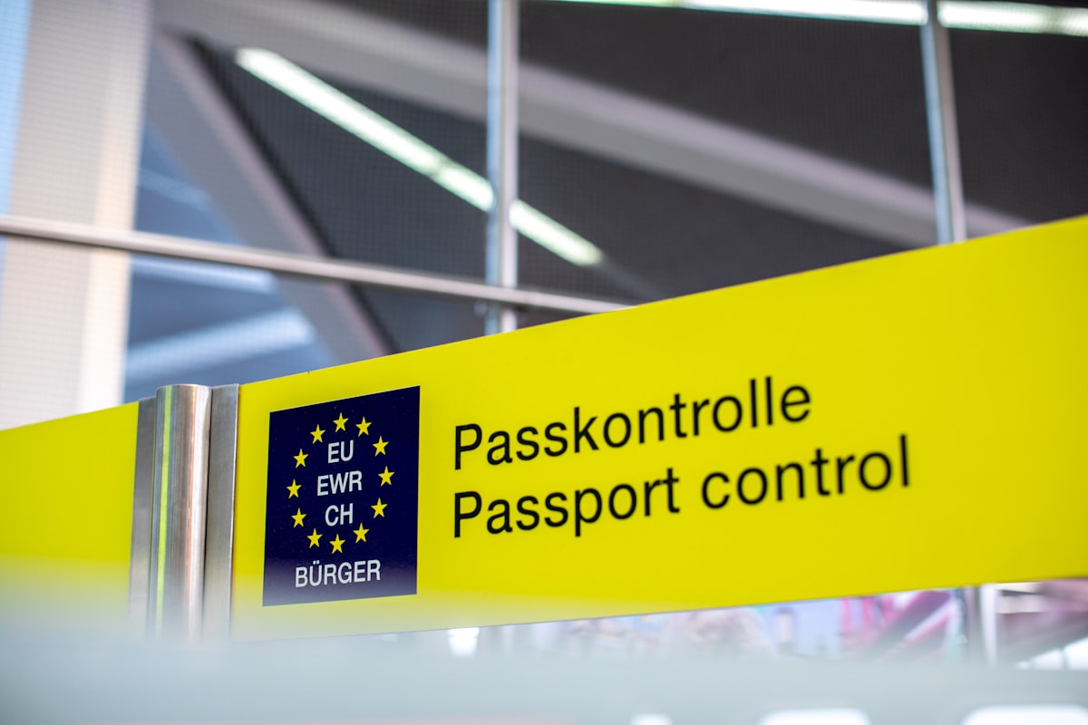 European passport control signage at a border, no identifiable people, for the EES/ETIAS piece on the EU's two new border systems