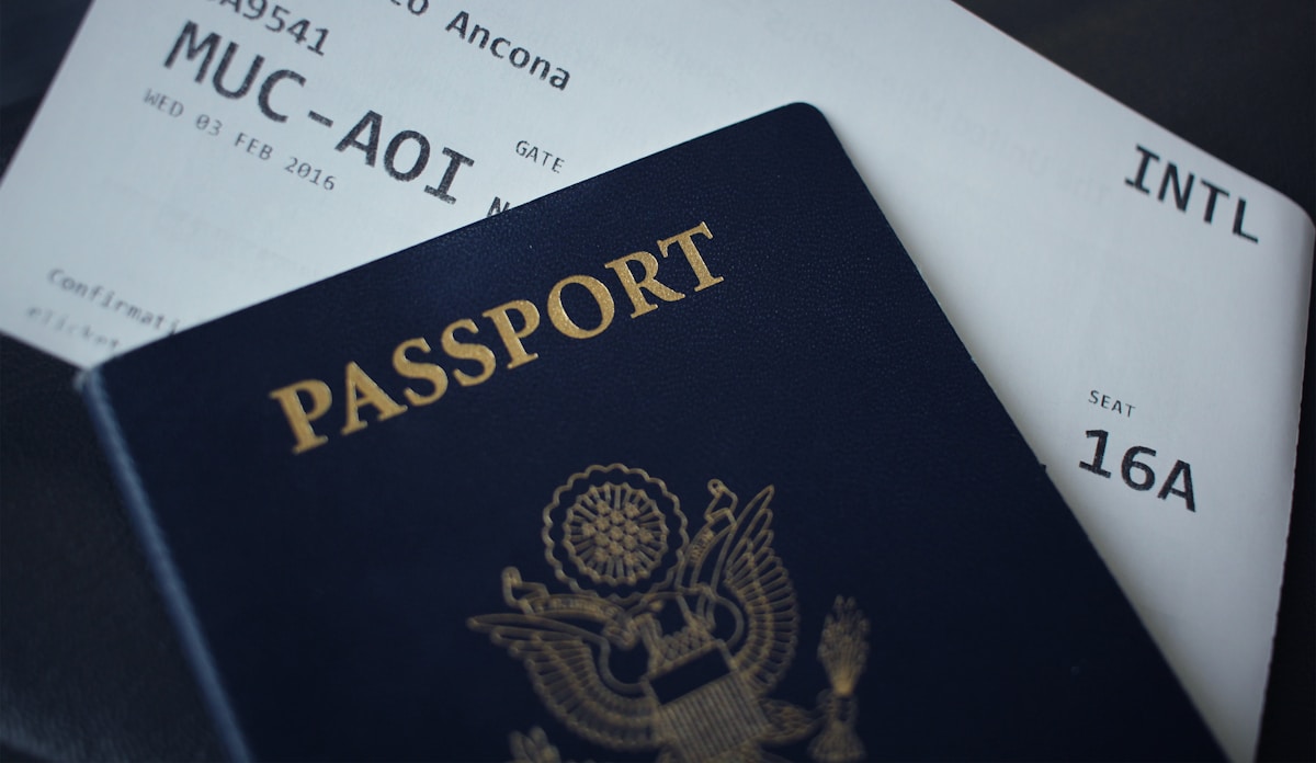 A passport booklet resting on white paperwork, no identifiable person and no readable nationality, for the piece on the world's most expensive tourist visas and fees