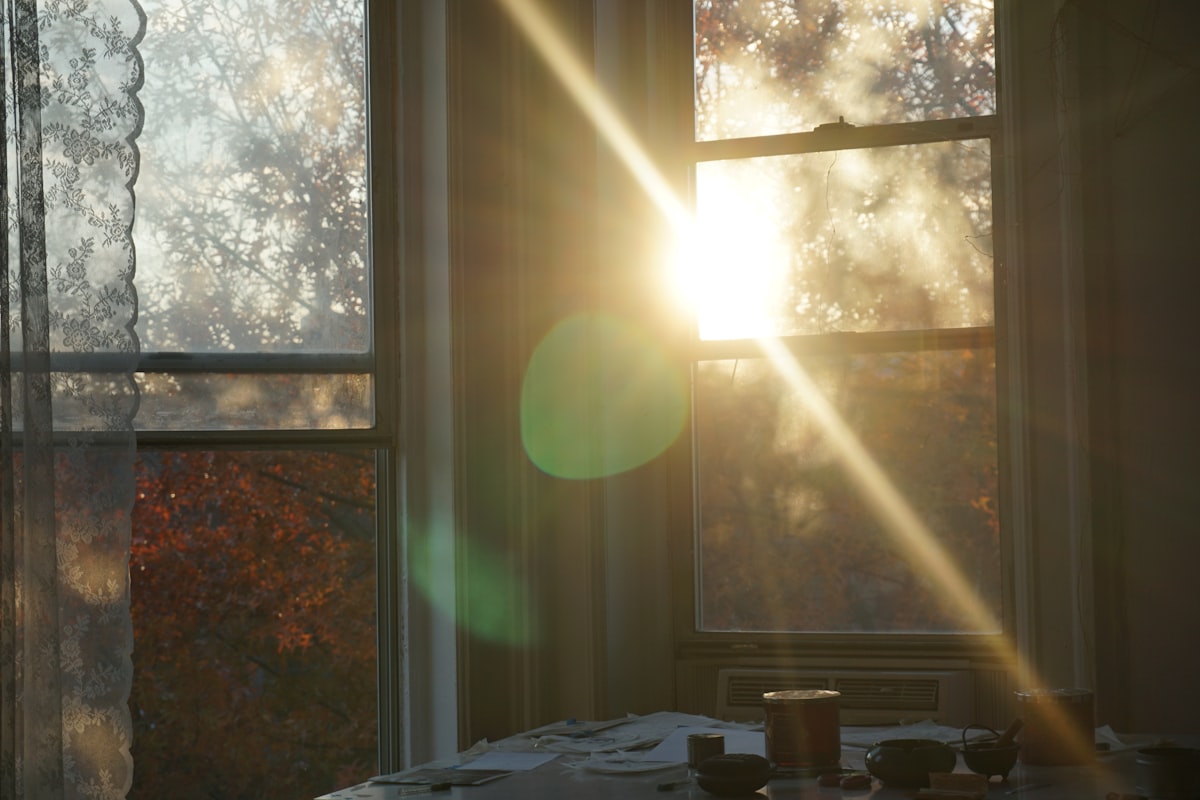 the sun is shining through the window of a room