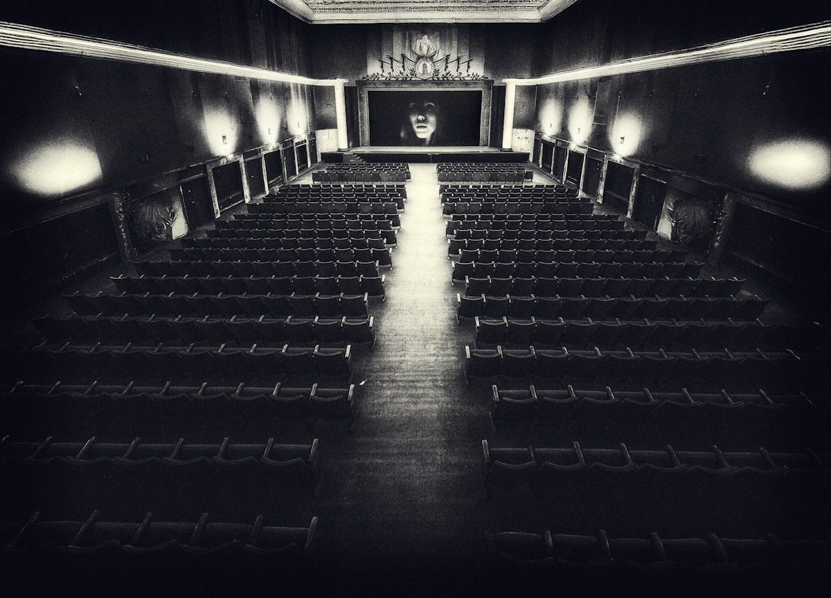 An empty vintage cinema auditorium with rows of seats facing a blank screen, no identifiable person and no readable brand name or logo, not a film still, for the piece on The Devil Wears Prada 2's nostalgia-driven box-office record