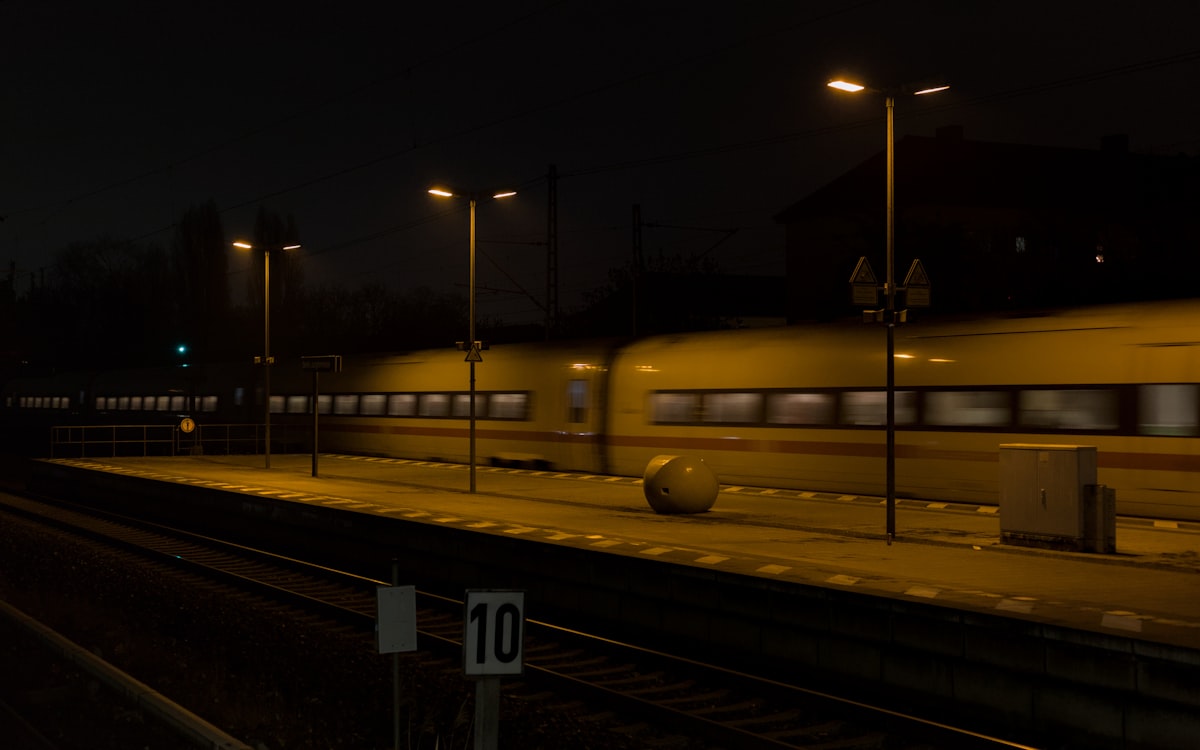 A train passing through a dimly lit station at night in Berlin, Germany