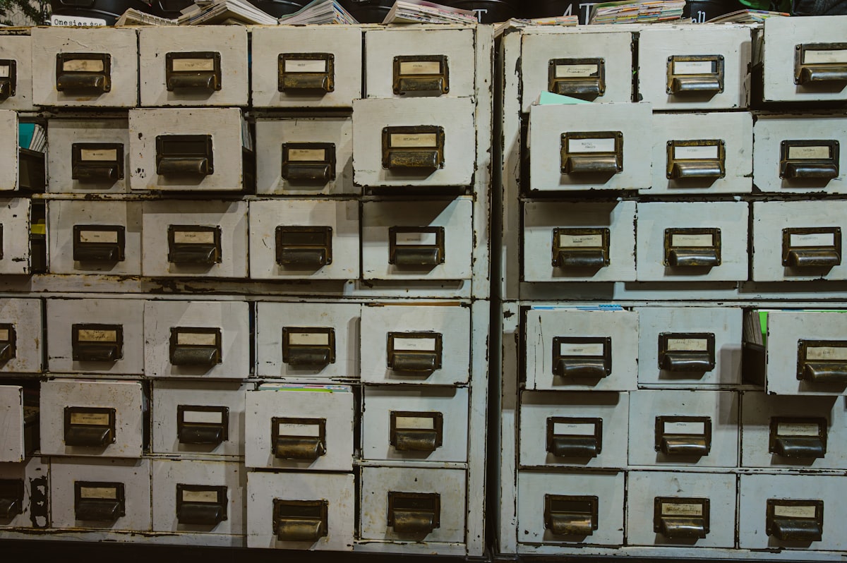 Rows of old card-catalog drawers with small illegible labels, no people, no interface and no readable brand in frame, for the piece on how precisely LinkedIn names the skills it tracks