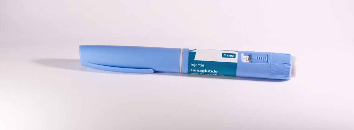 A pale blue prefilled semaglutide injection pen with a plain generic label lying on a white surface, no identifiable people and no manufacturer brand name or logo, for the piece on GLP-1 drugs as heart and kidney medicine